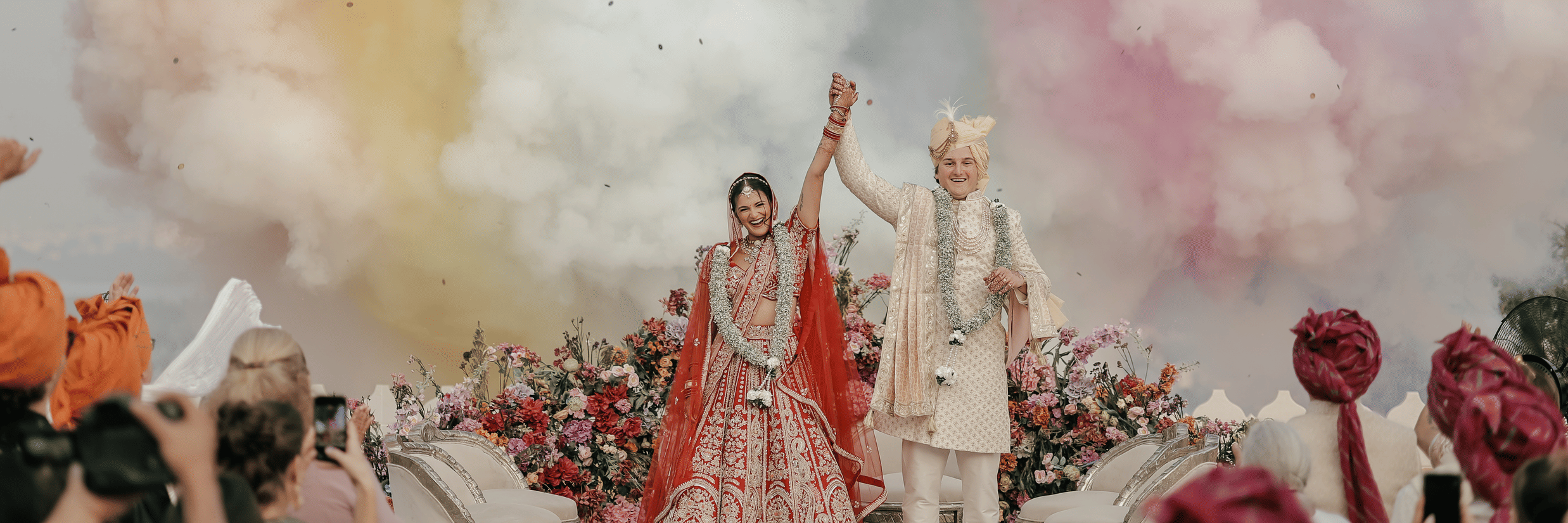 A newly wedded couple celebrating their wedding with colours flying around.