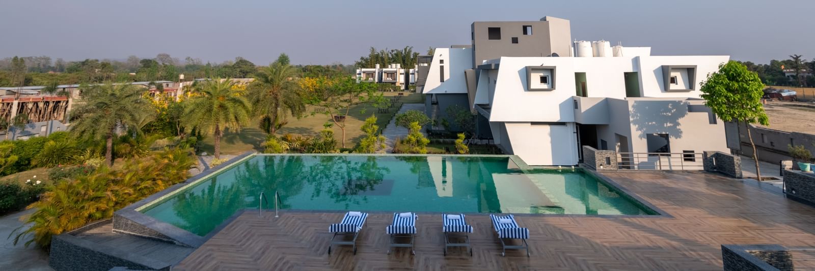 Swimming pool with sun loungers and scenic views - DLS Forest Vines Resort & Spa, Ramnagar (Jim Corbett)