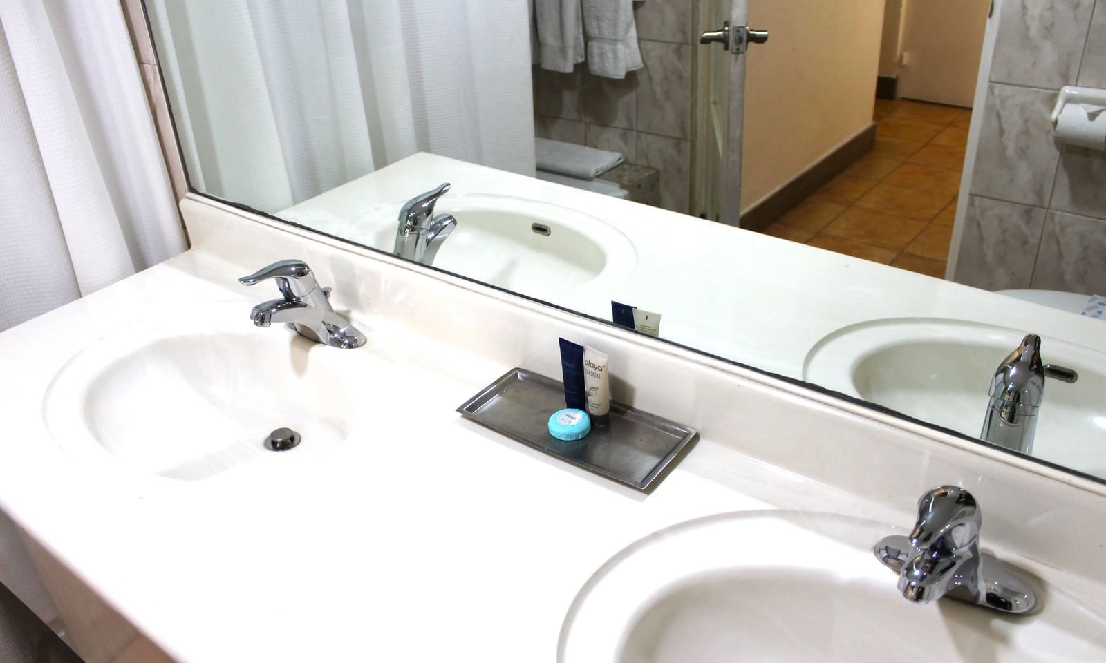 A modern bathroom vanity showcases two sinks, large mirrors, and various toiletries on the countertop |Superior Suite | Altamont Court, Jamaica