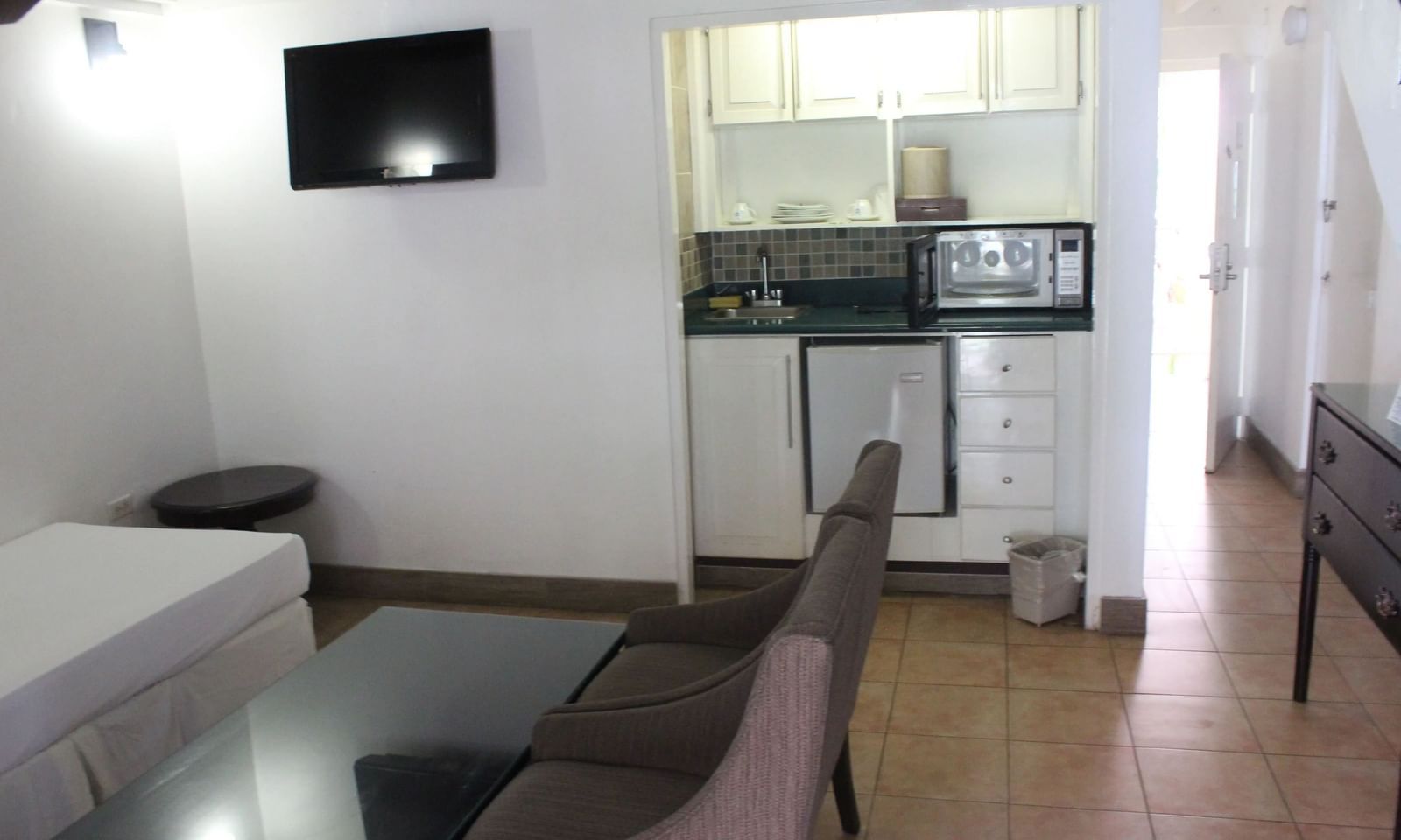 An interior room with a television mounted on the wall and seating | Junior Suite | Altamont Court, Jamaica