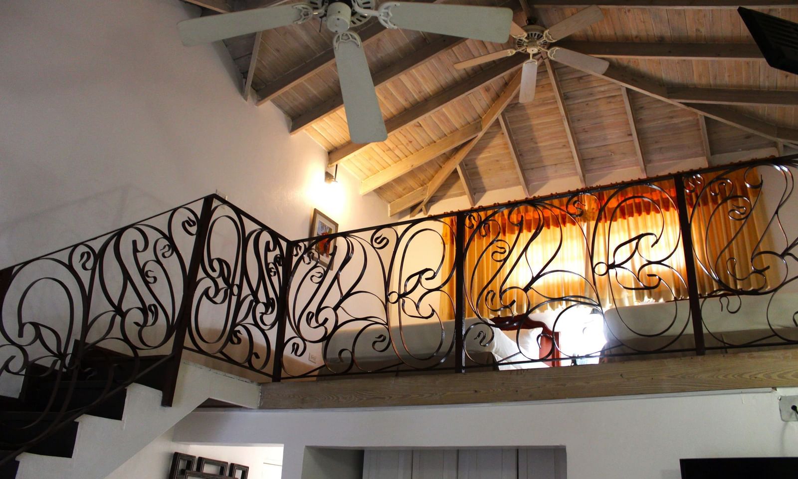 The loft or upper level within a room, showcasing a bed and decorative railings with a sloped ceiling | Junior Suite | Altamont Court, Jamaica
