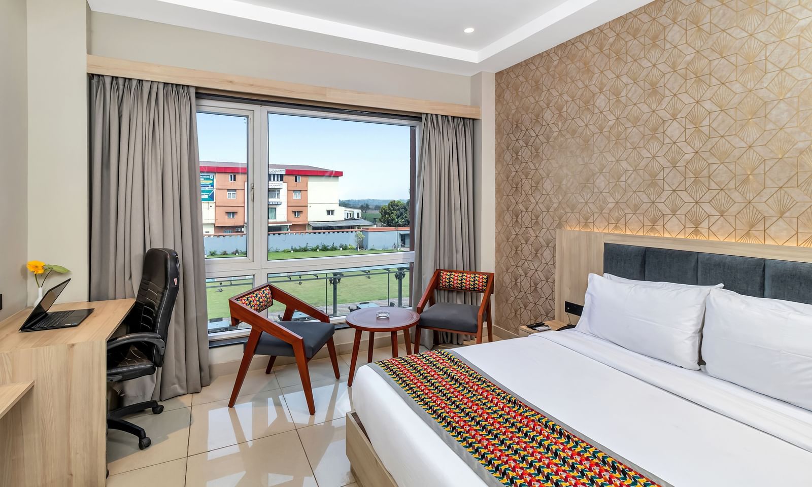 A hotel room with a bed, a work desk, and a seating area near a window with curtains | The Citi Residenci Hotel Banskopa