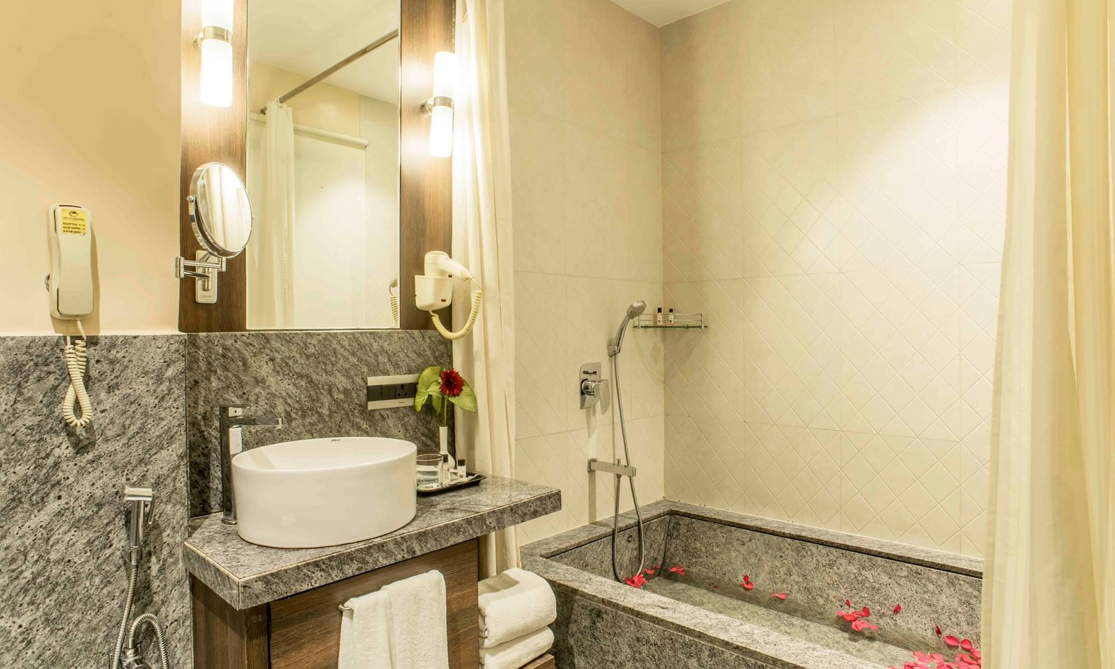 Elegant hotel bathroom with a soaking tub, a modern sink, and marble accents | The Citi Residenci Hotel Durgapur