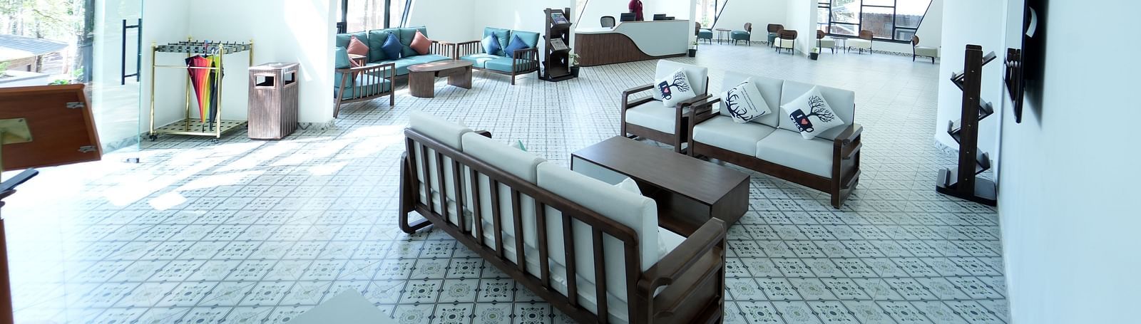 An image of a huge lobby with glass walls on one side and there are chairs at every corner of the room - TGI Redolent Resorts, Kushalnagar, oorg