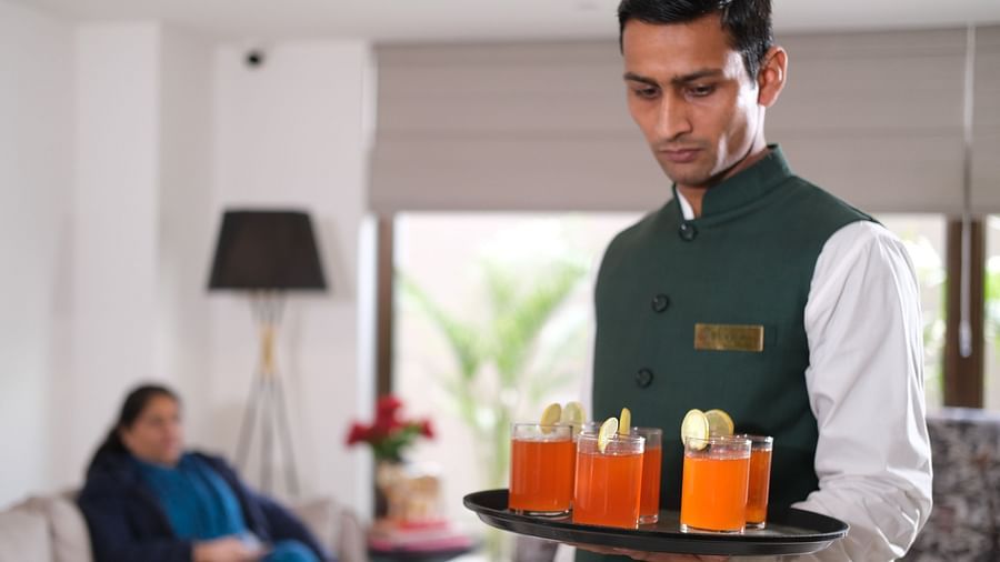 a waiter with a tray of welcome drinks at Triptam Hotel, Vrindavan