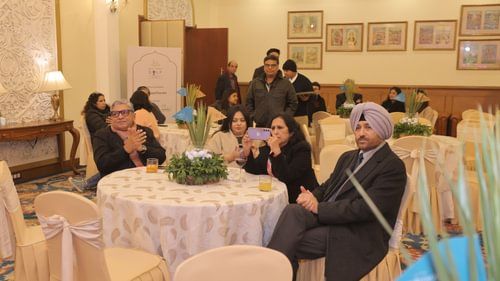 An image of a few people sitting on chairs with a table at an event at Heritage Village Resorts & Spa