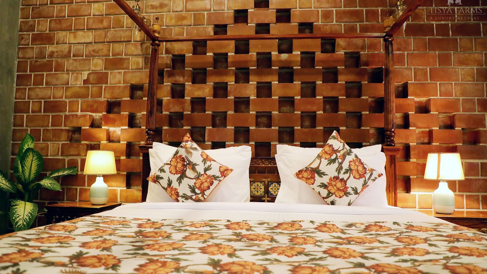 A bed with multiple pillows and an elegant, upholstered headboard at Tisya Farms, Gurgaon.