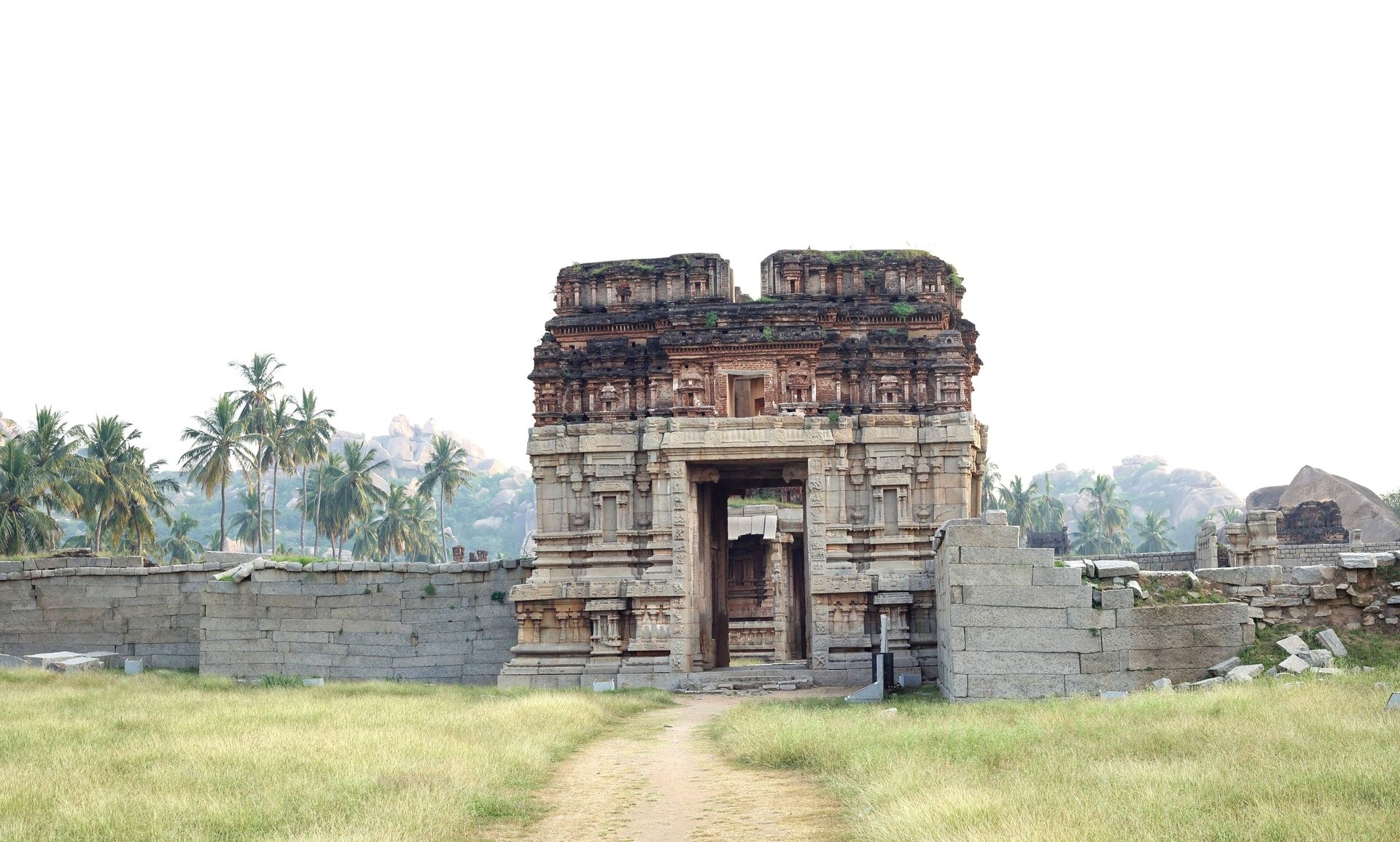 Ancient temple ruins in Hampi with a stone gateway.