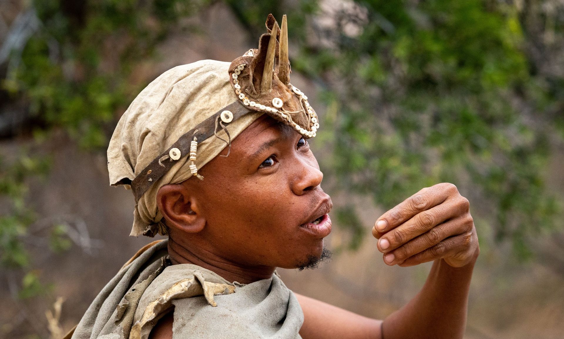 African man in traditional attire and unique headpiece.