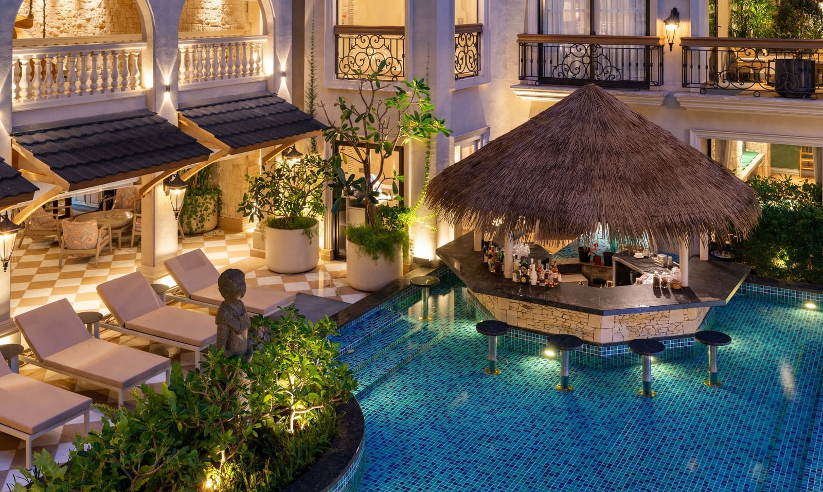 Close-up shot of the Splash Pool Bar featuring a pool-side bar counter cover with thatched roof at The Evren, Vagator.