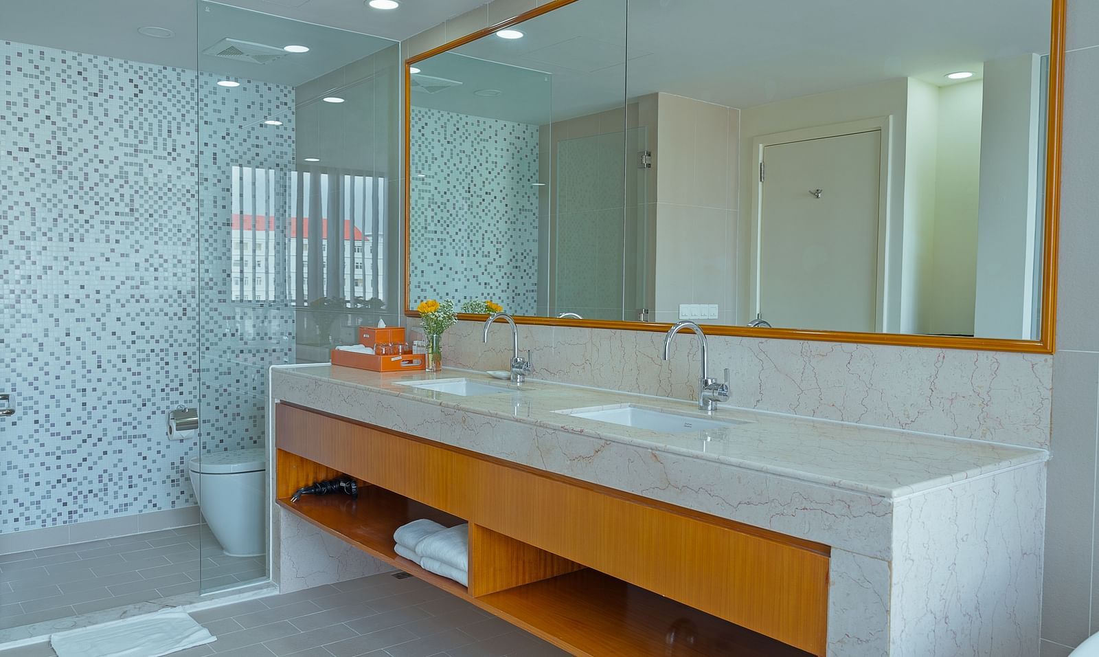A bathroom with a large mirror, sink, and countertop | Penthouse | Central Mansions, Phnom Penh