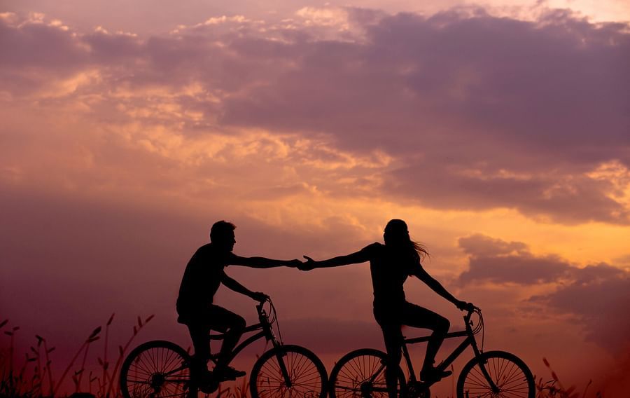 couple holding hands while cycling