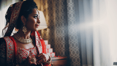  Indian bride wearing a traditional embroidered red lehenga and gold jewellery.