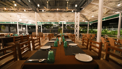 Picture featuring the restaurant, with dining tables arranged and brightly lit.