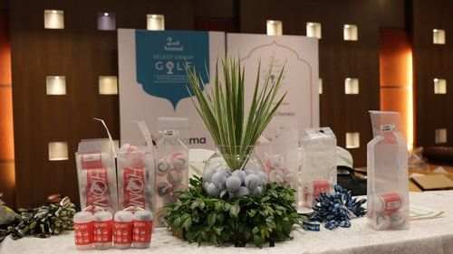 A table displays arranged items, including packaged goods and a central floral arrangement with spheres. - Heritage Village Resorts & Spa