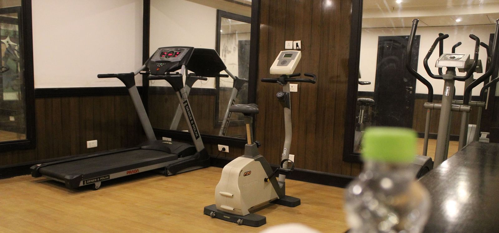 An image of a gym at Inde Hotel Vista Woods featuring treadmill , cardio machine, and other fitness quipment