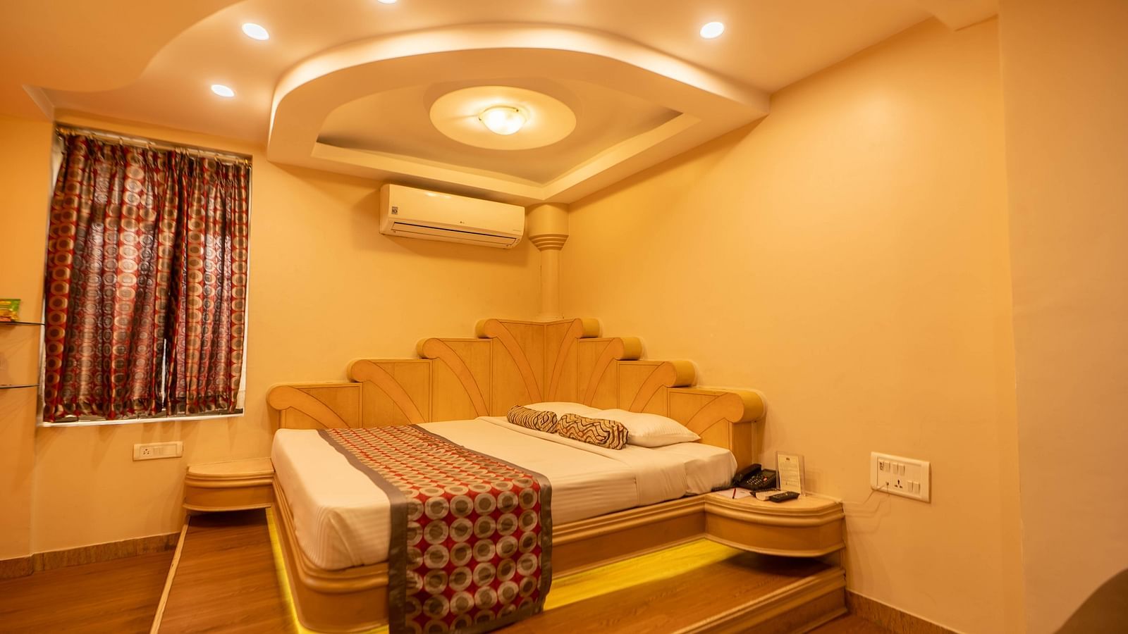 The suite at Hotel Pai Viceroy Jayanagar featuring warm interiors and a queen sized bed