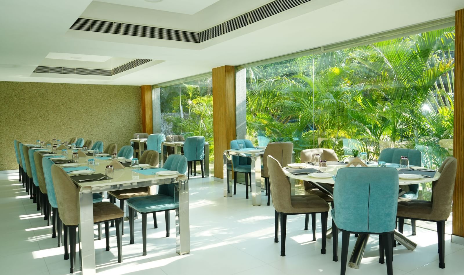 Dining tables and chairs arranged neatly in a bright restaurant space at Grande Bay Resort & Spa.