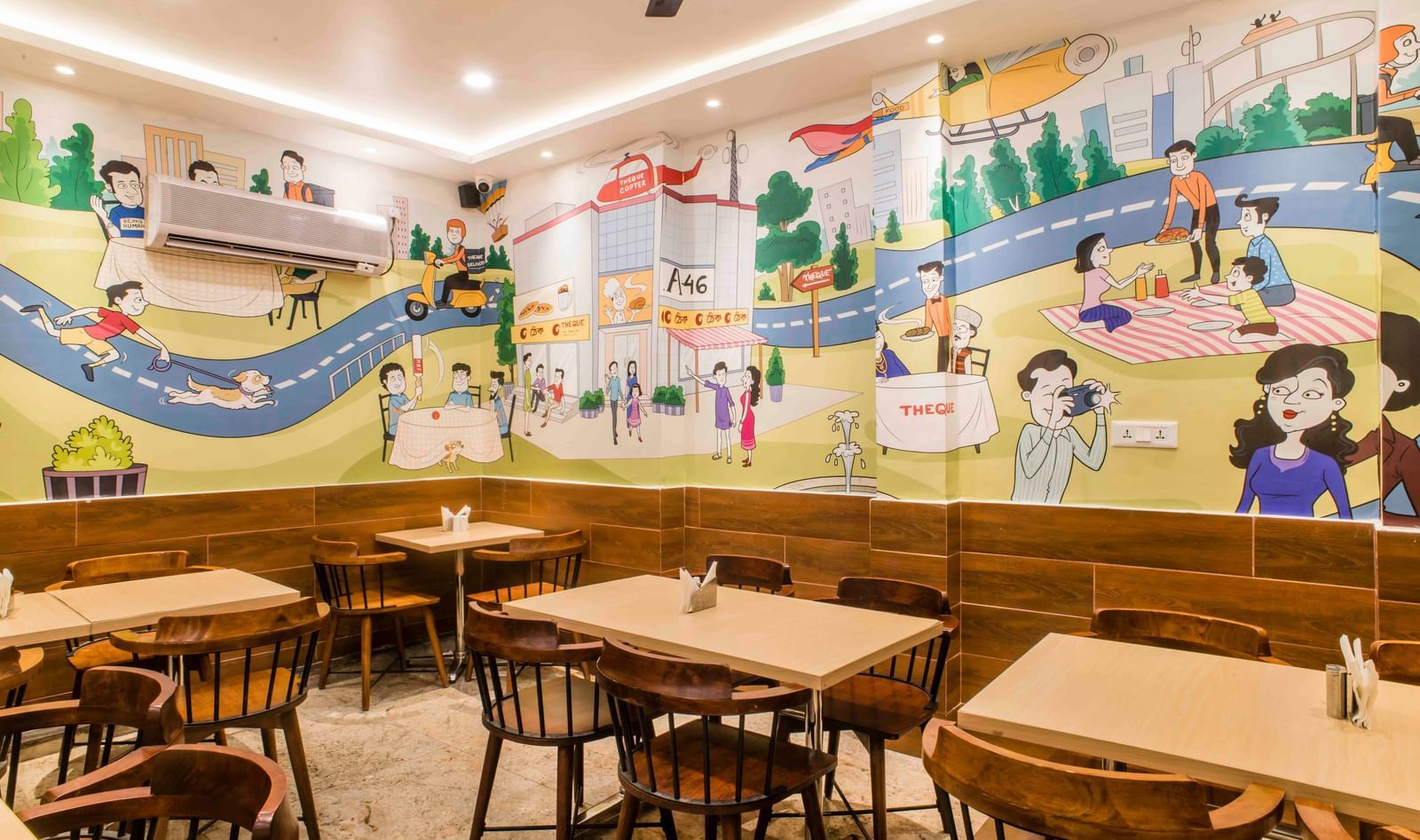 A spacious dining area with colourful wall art and wooden furniture at The Citi Residenci Hotel, Durgapur.