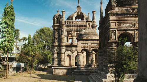 An image of temples with dome structure on the tip and the area is surrounded by a few trees