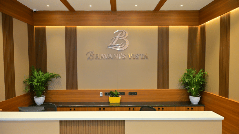 Reception desk of Bhavanis Vista By Icon featuring a counter, signage, and potted plants.