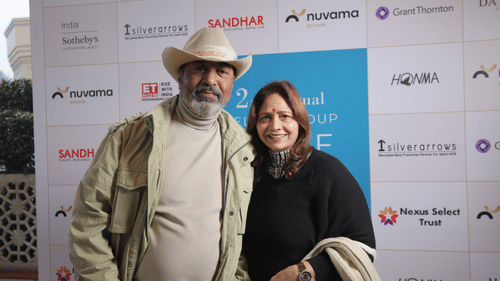 A couple posing in front of a sponsored brands board to Annual Golf celebration at Heritage Village Resorts & Spa