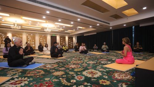 A group of people meditating by sitting on a yoga mat in a room at Heritage Village Resorts & Spa