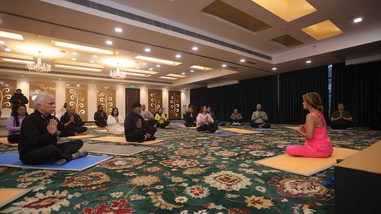 A group of people meditating by sitting on a yoga mat in a room at Heritage Village Resorts & Spa
