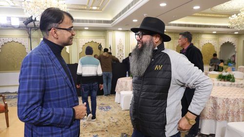 An image of one person talking to another at an event at Heritage Village Resorts & Spa