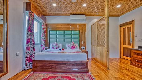 Cosy bedroom with king-size bed, soft lighting and warm interiors at Royal Comfort Regency for a restful night's sleep.