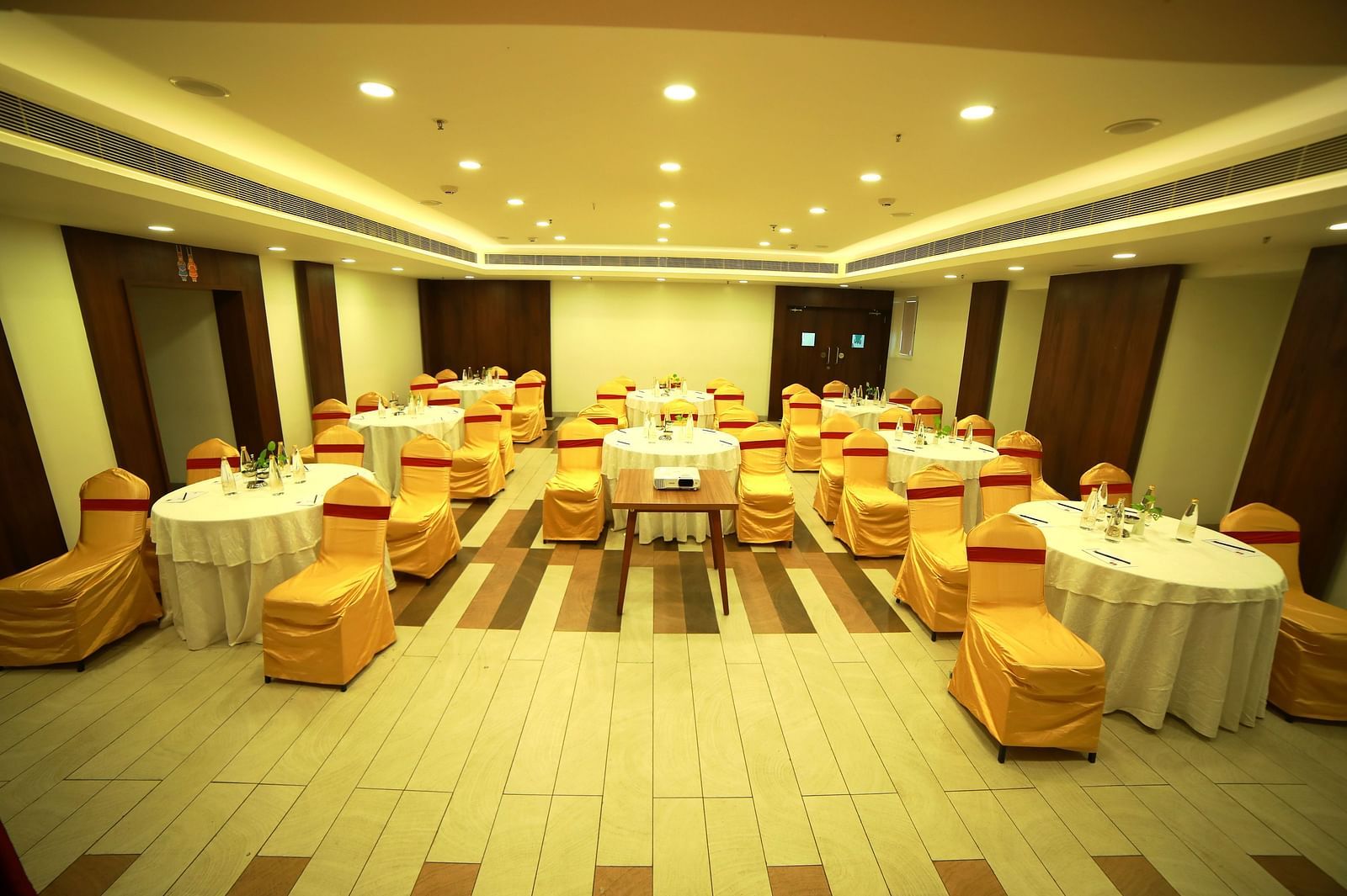 A spacious event hall with elegant ceiling lights illuminating the room at Zibe Salem by GRT Hotels
