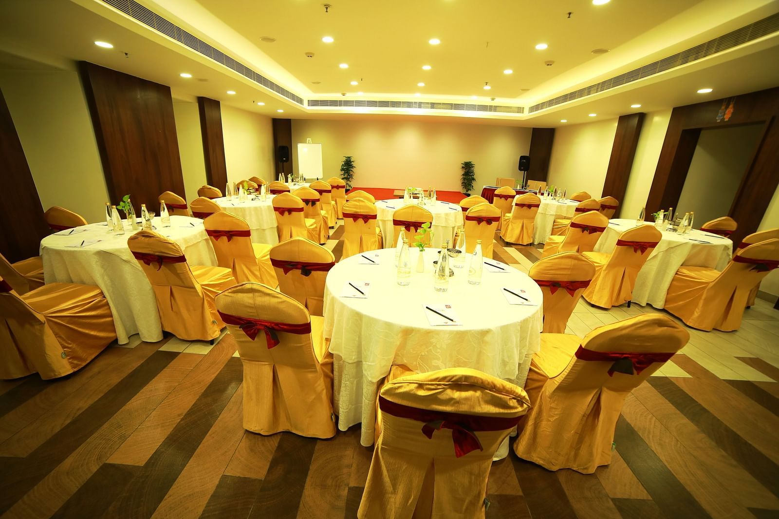 close up view of event hall with elegant ceiling lights illuminating the room at Zibe Salem by GRT Hotels