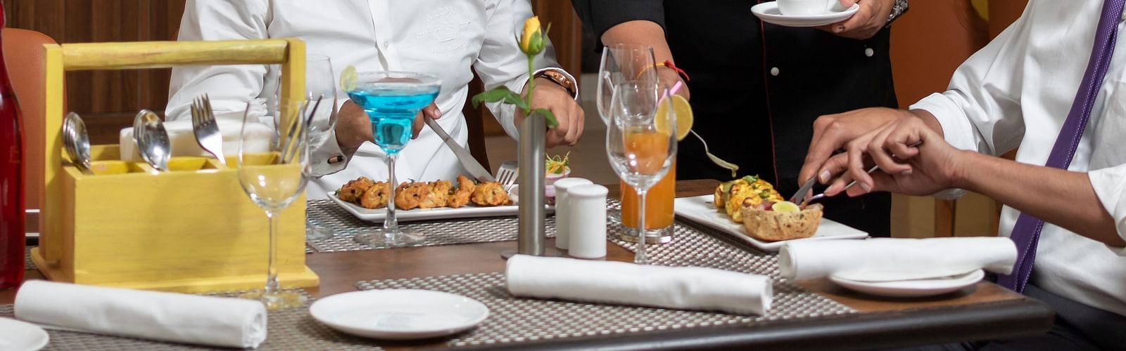 Image of a chef serving food to two people at Cafe Inde | Inde Hotel Cyber City