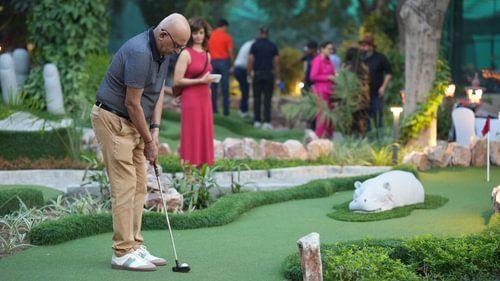 Close-up of a participant putting on a golf course during an evening event
