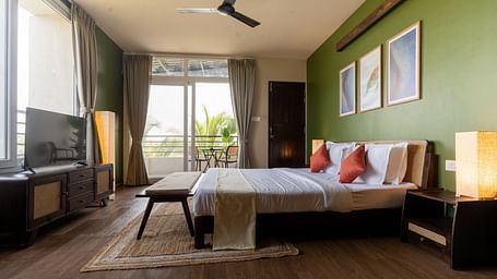 Spacious bedroom with natural lighting, modern decor, and a cosy seating area at Kssemya.