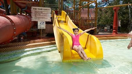 An image of the Zoomroo Slide at Water Kingdom where a girl is sliding down into the water