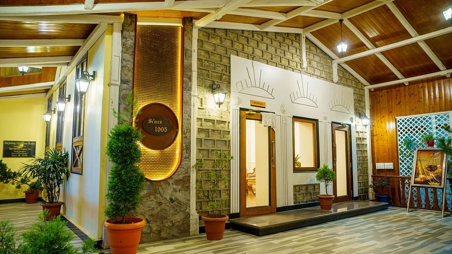 A well-lit interior space of Orsino Spa Resort with wooden ceilings and walls, featuring decorative wall art and potted plants.