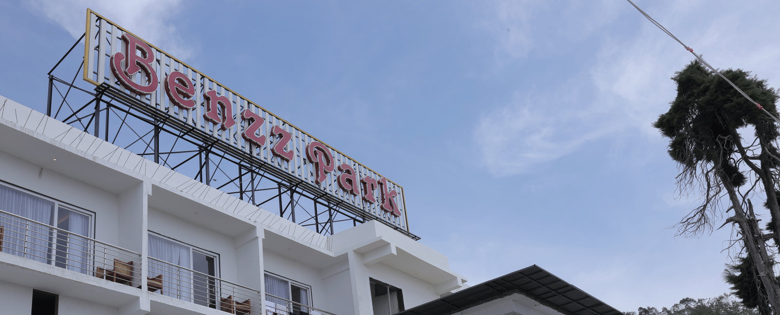 The exterior of Benzz Park, Kodaikanal hotel building under a clear sky.