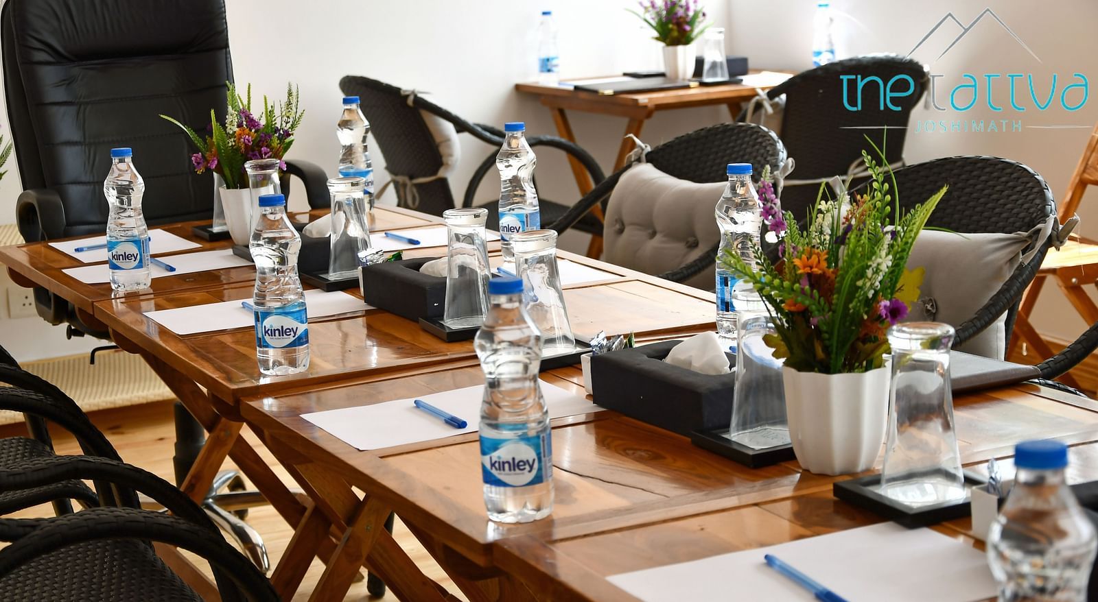 close up image of the table in the conference hall with white sheets kept on the table at the tattva, joshimath