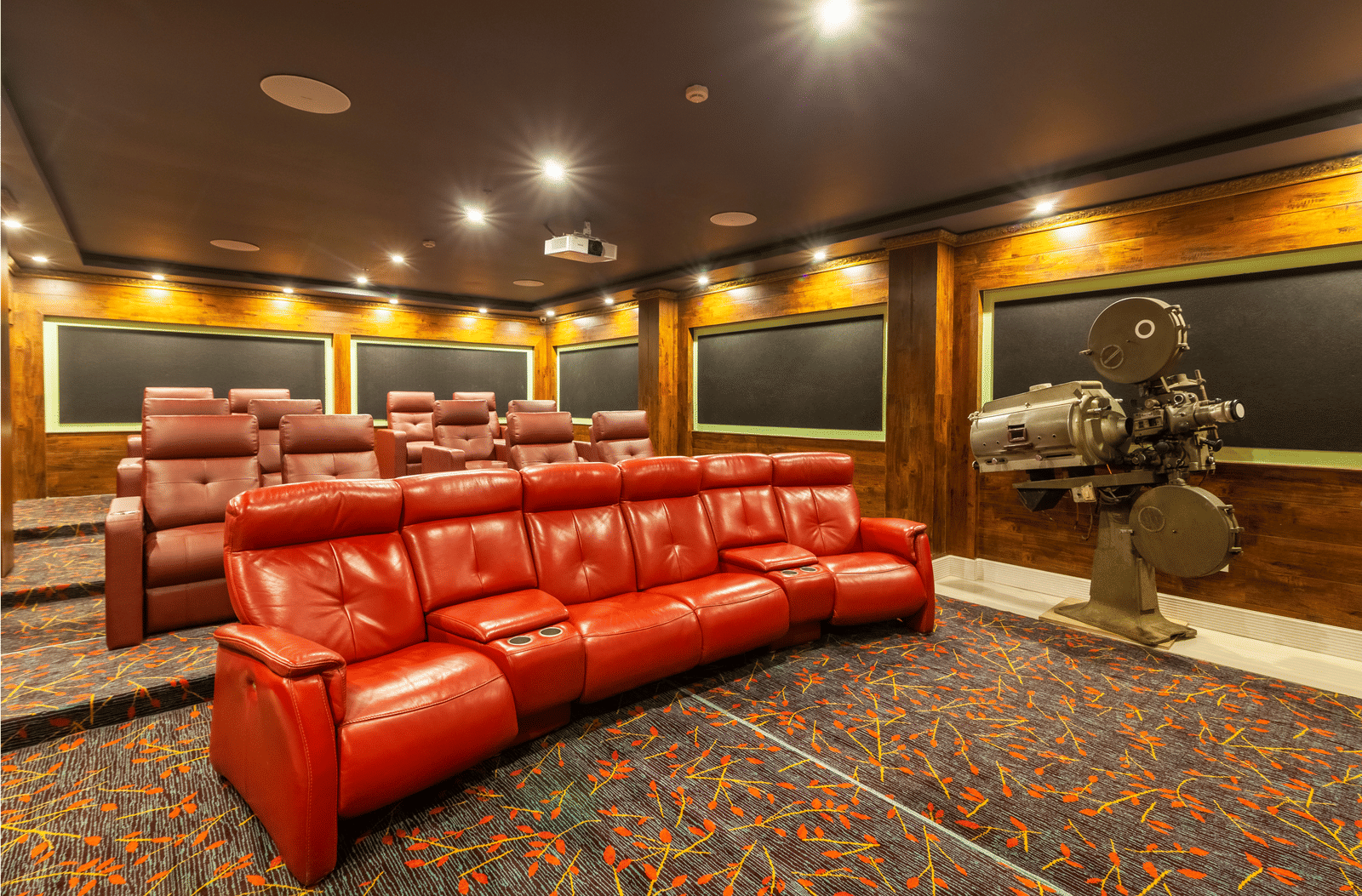 Box Office private theatre with red leather recliner seats, acoustic wall panels and a vintage film projector at MAYFAIR Himalayan Spa Resort, Kalimpong.