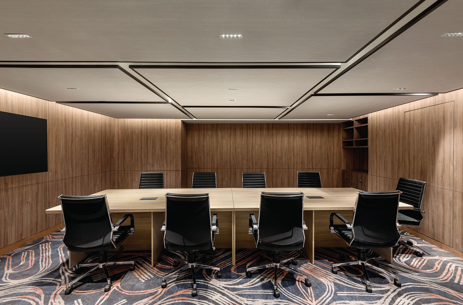 Ramada Encore by Wyndham, Bhiwadi | Meeting room, long conference table, black chairs, large screen, wood paneling.