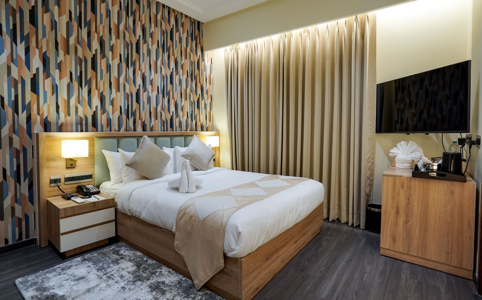 Full view of the Deluxe room featuring a double bed along with a beige coloured bed runner spread over it at M2 Square by Monday Premium.