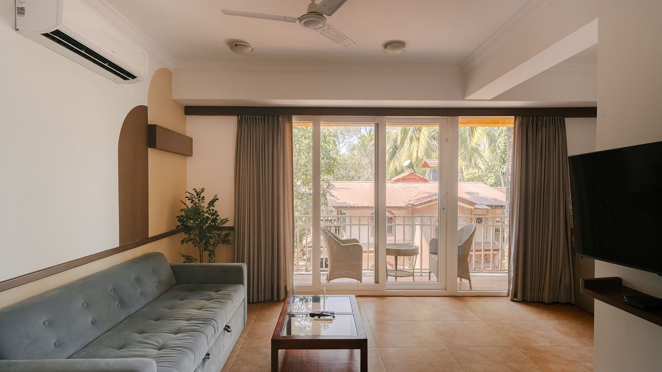 Well-lit living room with a cozy seating area and a balcony at the Two BHK apartment in Richmonde Ananta Elite, Goa.