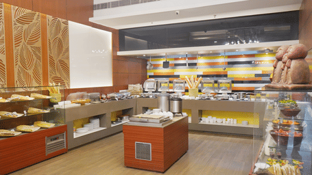 A side angle view of buffet counter at Nemesia restaurant featuring a variety of desserts.
