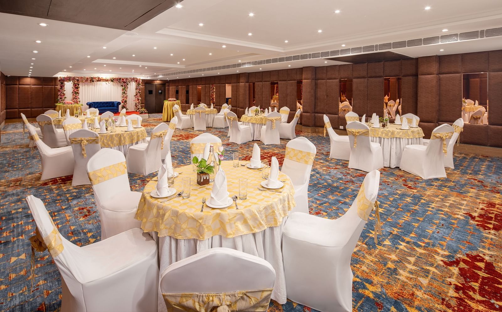 An image of a banquet hall with several chairs and table sets spread out - Brij Eternity, Vrindavan