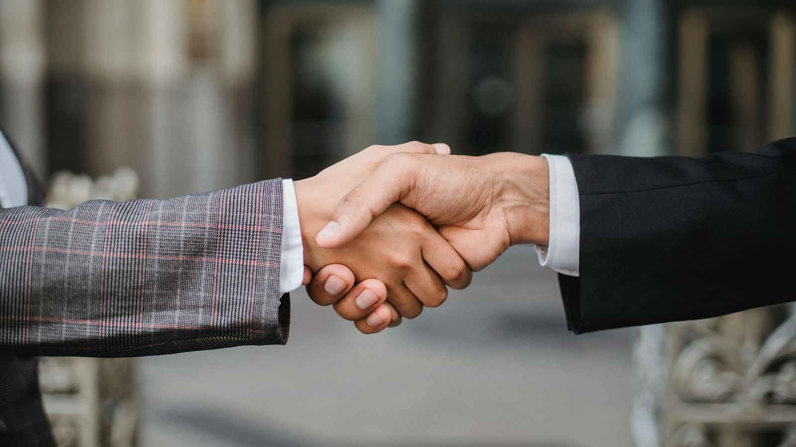 A close-up shot of two individuals in business attire shaking hands.