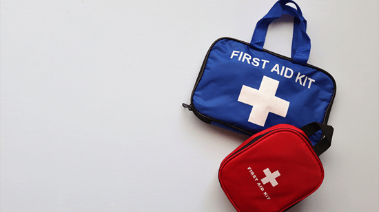 Blue and red first aid kits with medical cross symbols displayed together.