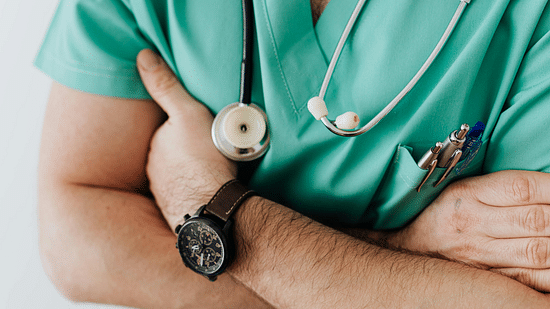 A close up shot of a person with a stethoscope wrapped around his neck