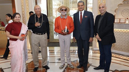 Group photo of distinguished guests with the hotel manager in a stylish reception area.