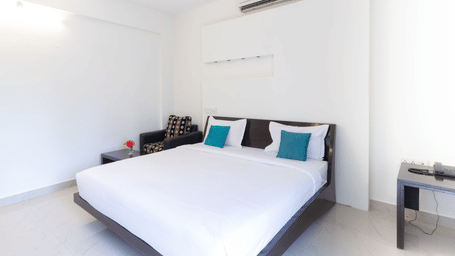 Clean and well-lit standard room with double bed at Sanctum Suites Domlur Bangalore